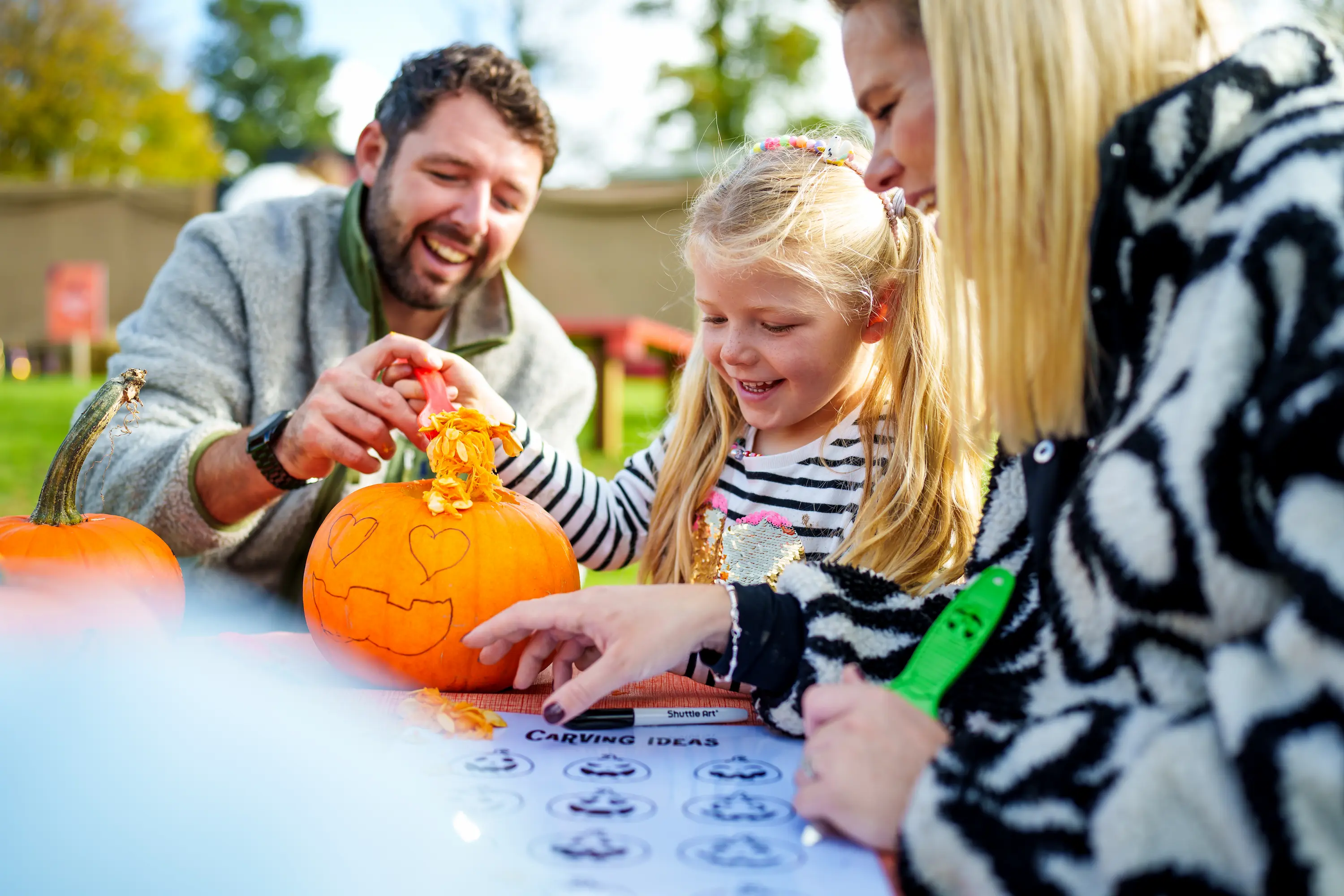 A family carving a pumpkin at Pumpkin Fest 