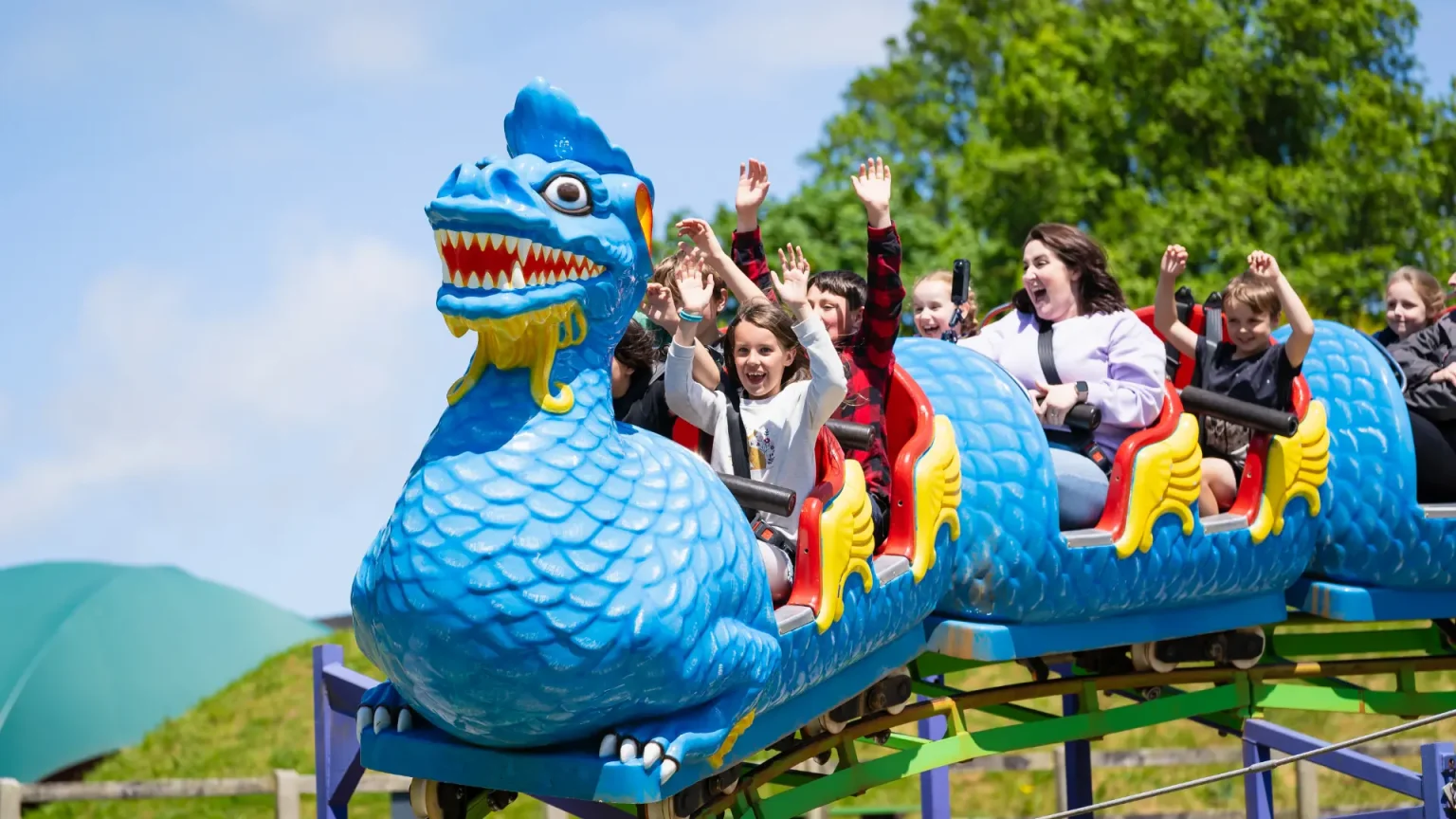 People on the dragon rollercoaster with hands in the air
