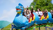 People on the dragon rollercoaster with hands in the air