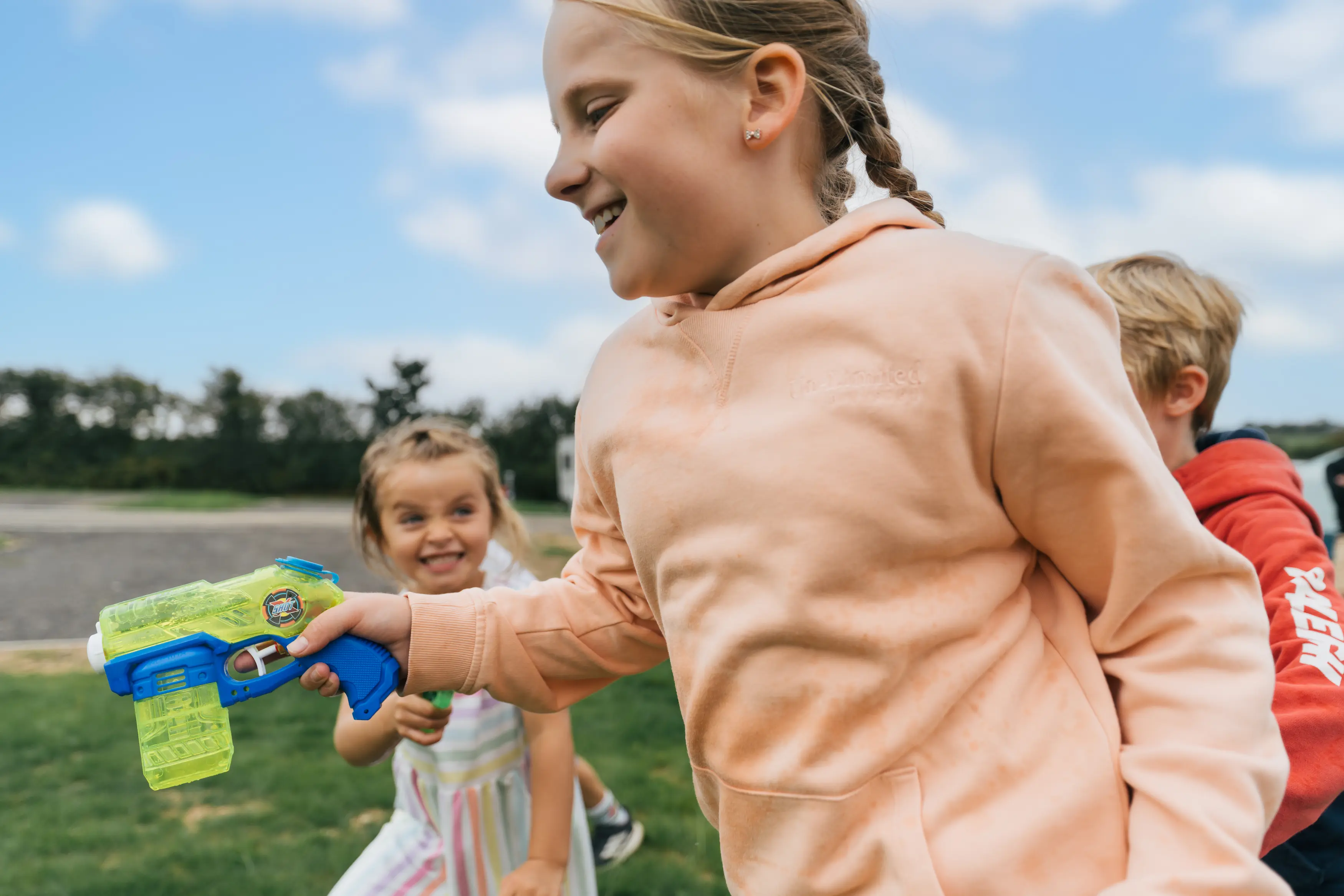 Children playing with water pistols at the camping and glamping site
