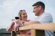 A man and woman cheersing wine glasses