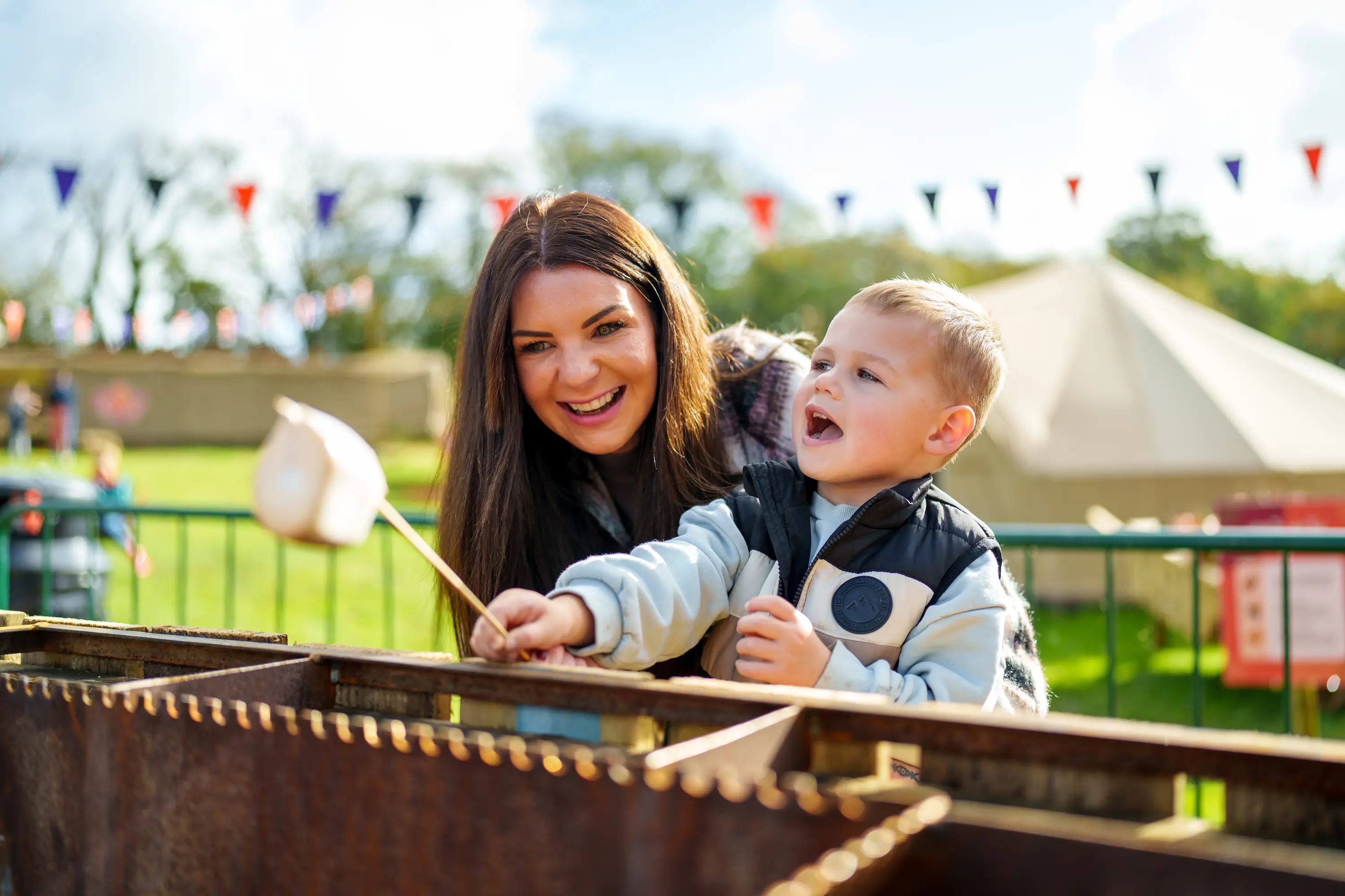 A woman and boy toasting marshmallows at Pumpkin Fest 