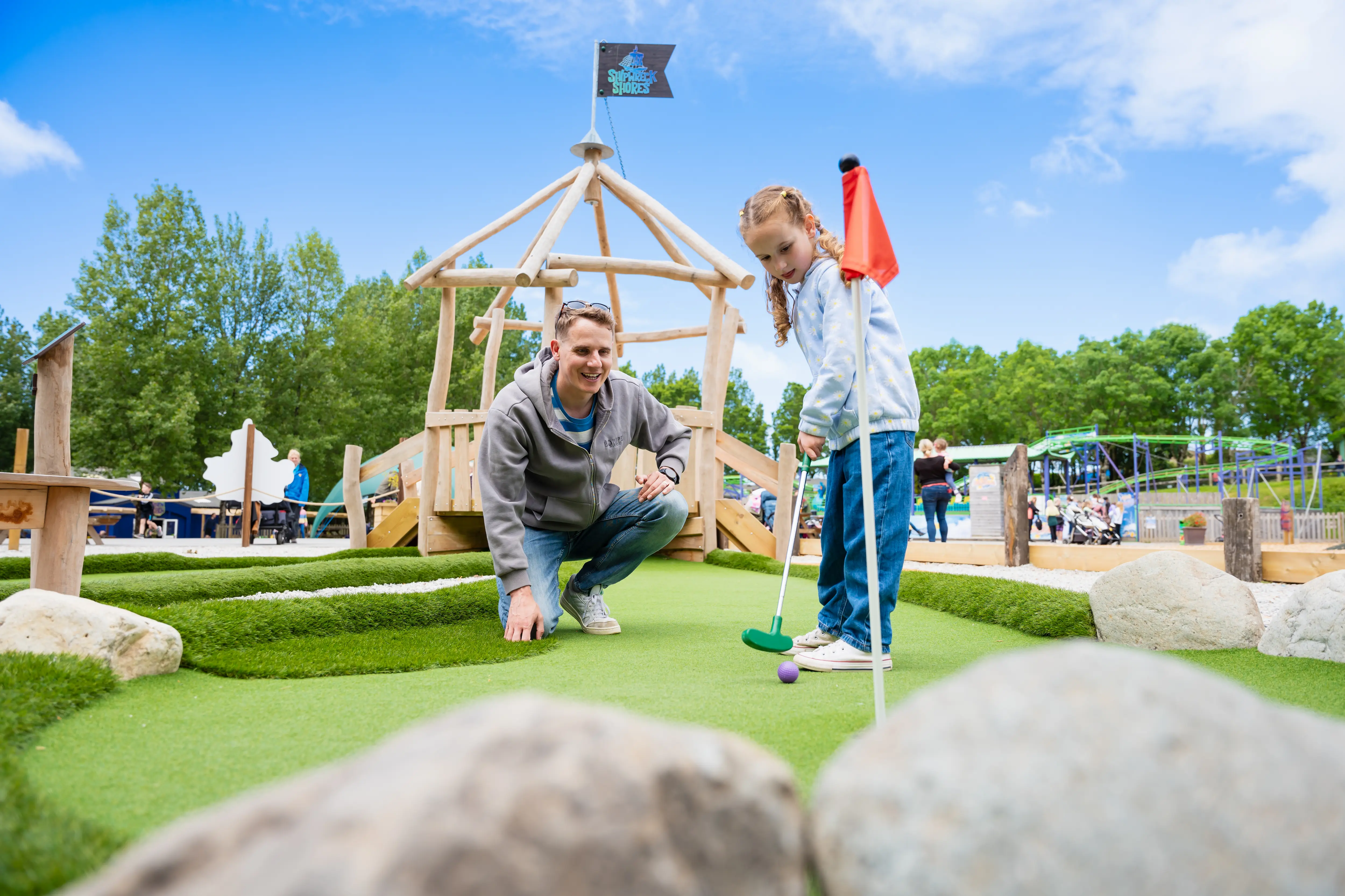 Girl and dad playing adventure golf