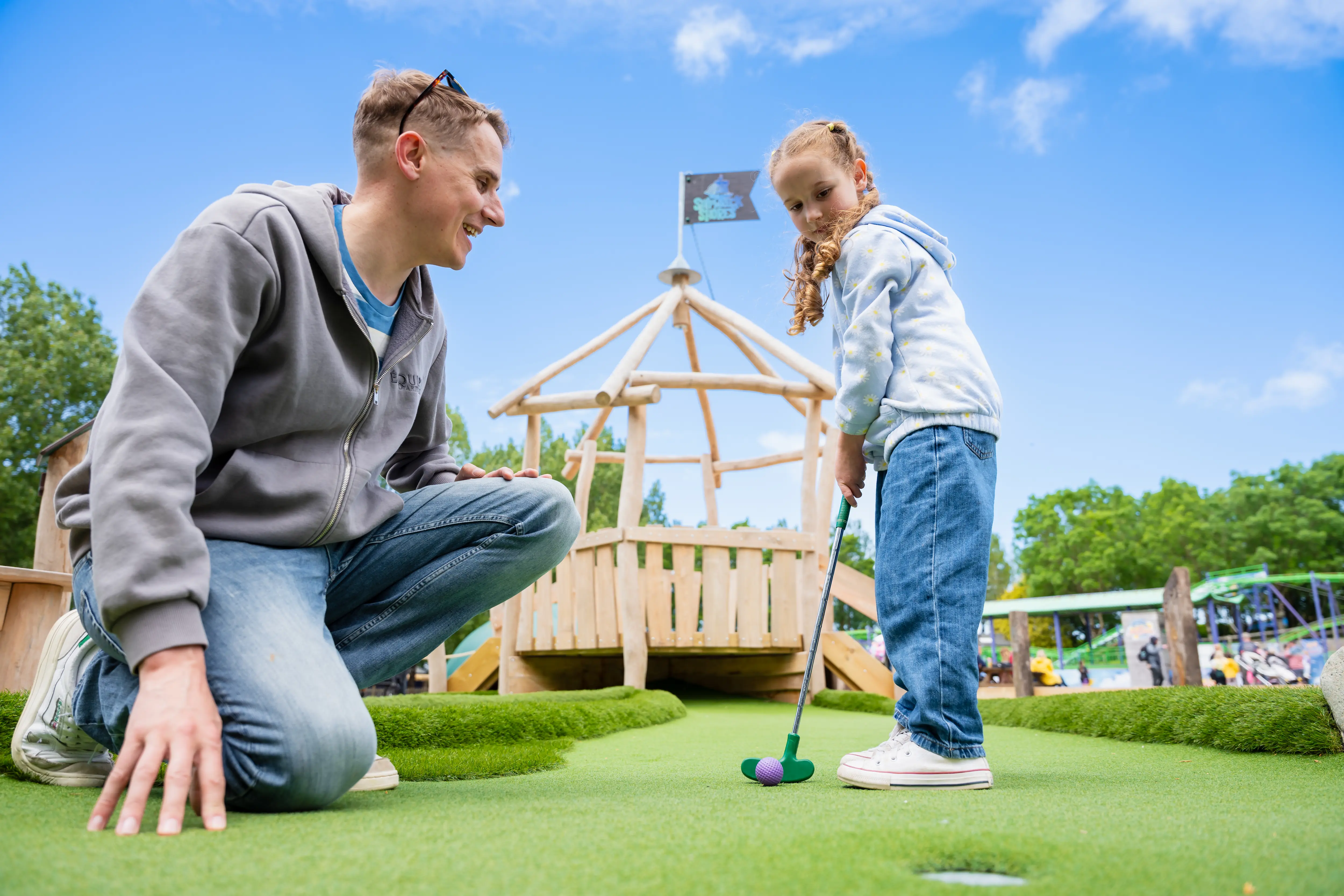 Girl and dad playing adventure golf