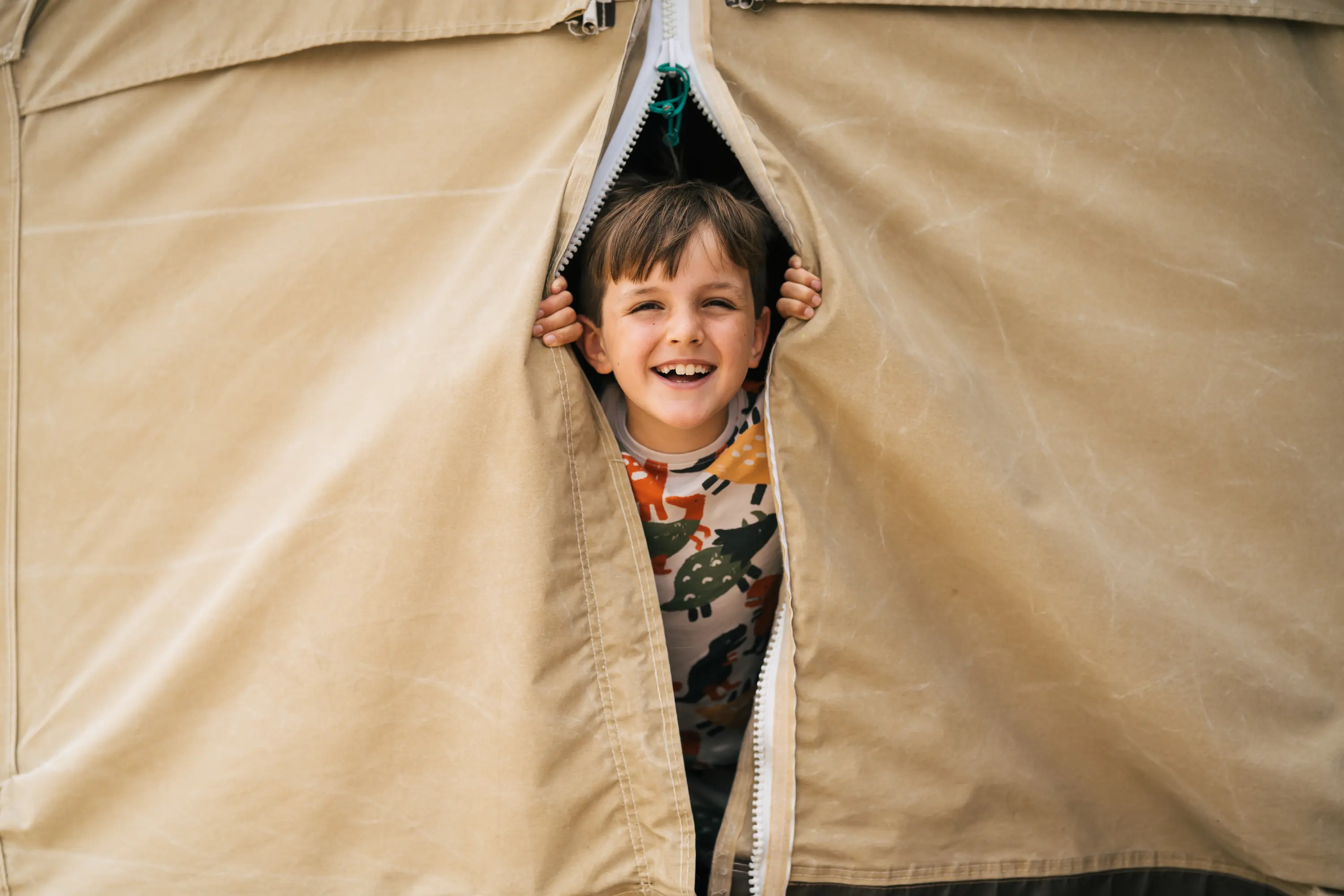 A boy with his head out of the glamping bell tent