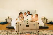 A family sitting on the bed inside the glamping bell tent