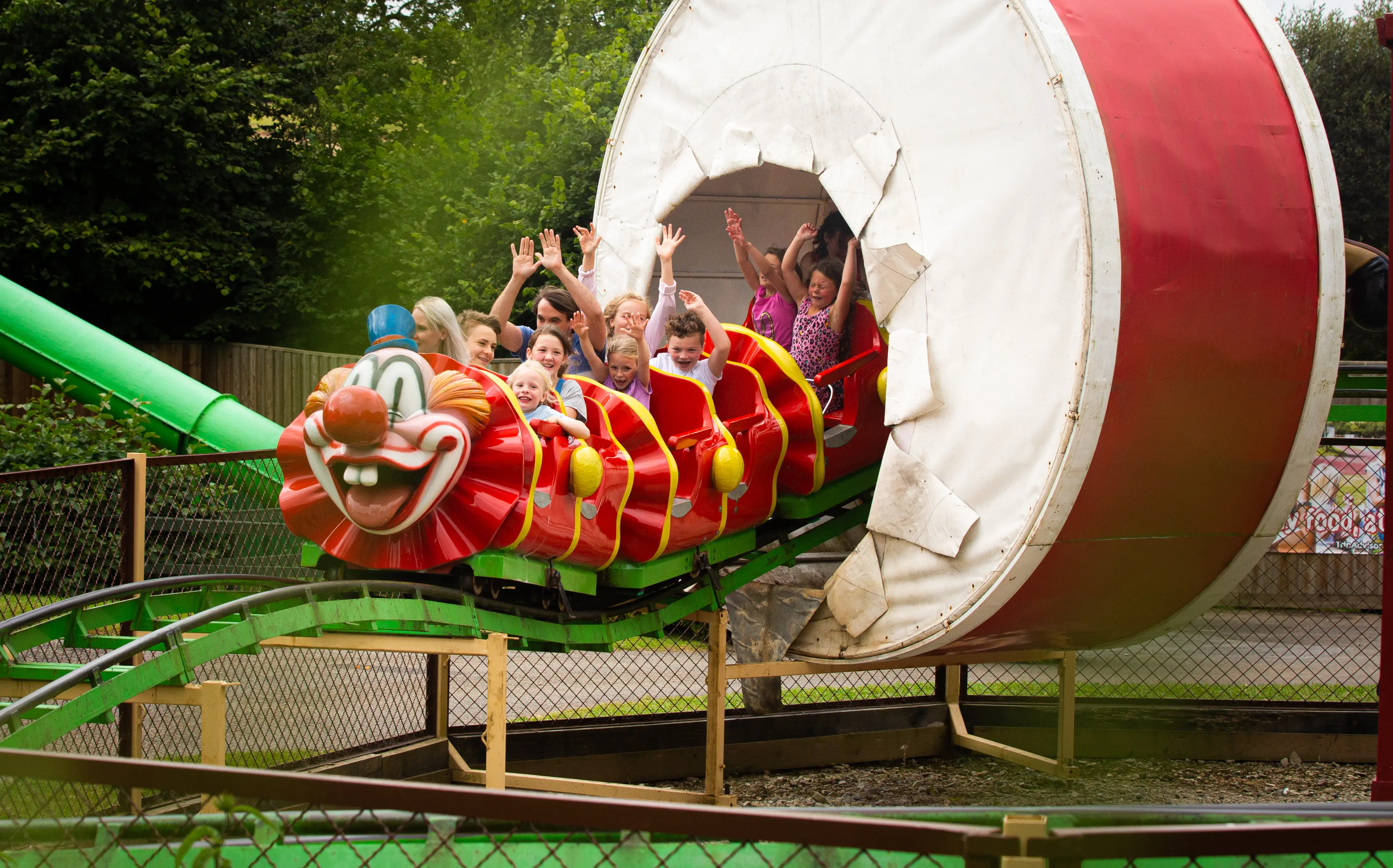 People on the Clown Coaster ride with their hands 